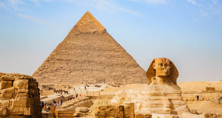 Vue emblématique de la Grande Pyramide de Giza s'élevant derrière le Sphinx dans le désert.