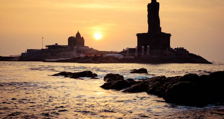 Gouden zonsopgang boven de oceaan werpt een silhouet op het Vivekananda Rock Memorial en het Thiruvalluvar Standbeeld in Kanyakumari.