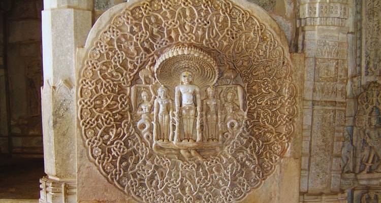 Intricate circular Jain marble carving depicting deities at Ranakpur Temple.