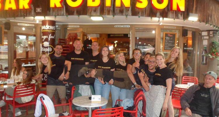 Große Gruppe in passenden Hemden vor dem Café Bar Robinson posierend.