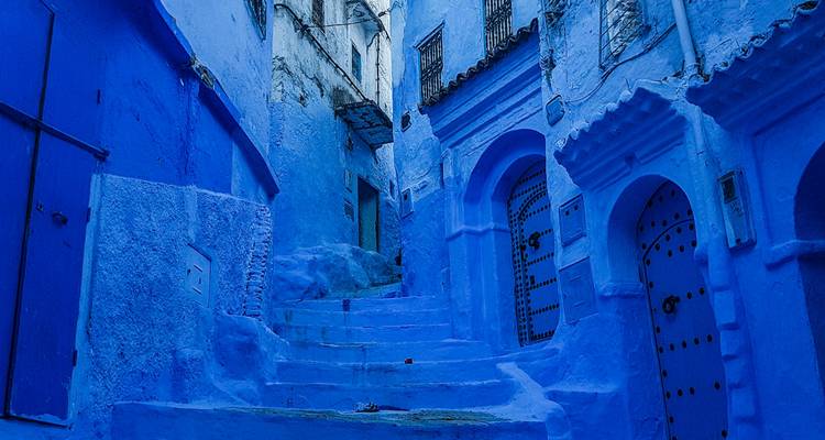 Quiet, narrow staircase in Chefchaouen painted in deep shades of blue.