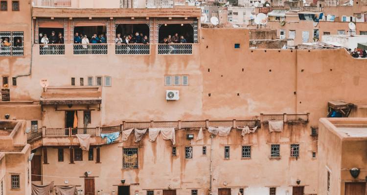 Adobe tannery or residential wall with open terrace where people peer over the medina in Fes.