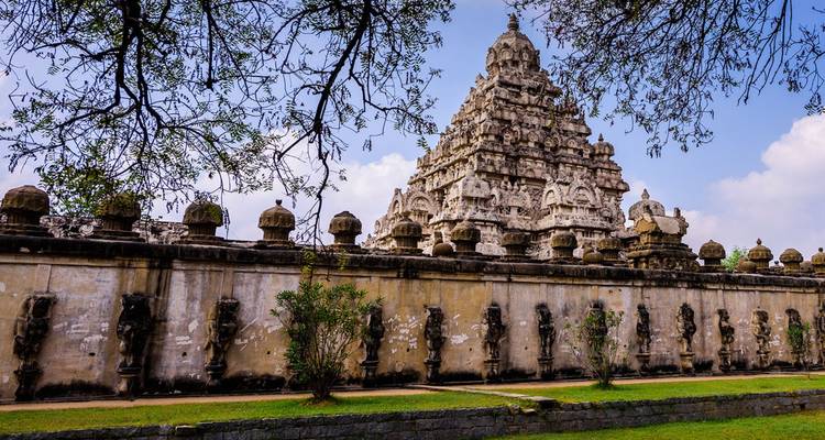 Stone Kailasanathar Temple complex surrounded by fortified walls and crowned by an intricate tower.