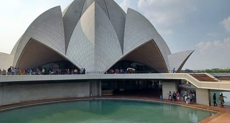 Les foules font la queue devant les vastes arches blanches du Lotus Temple de Delhi, à côté de son bassin de réflexion turquoise.