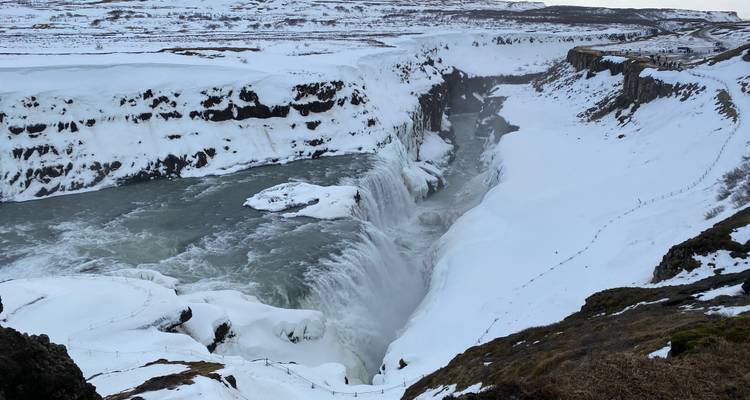Mächtiger Wasserfall, der sich durch einen schneebedeckten Canyon in einer Winterlandschaft stürzt
