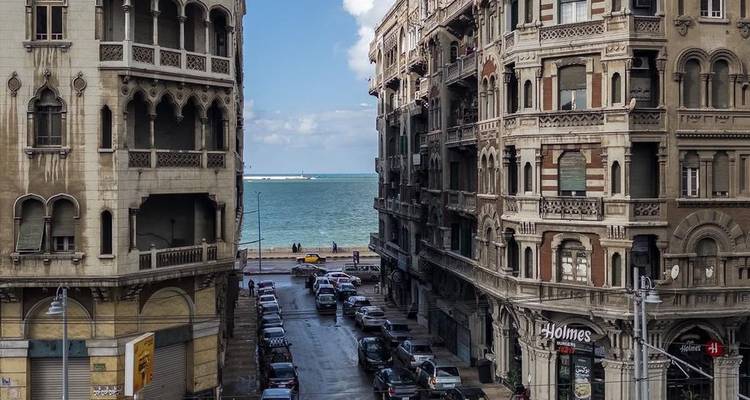 Rue historique d'Alexandrie bordée de bâtiments ornés donnant sur la mer Méditerranée.