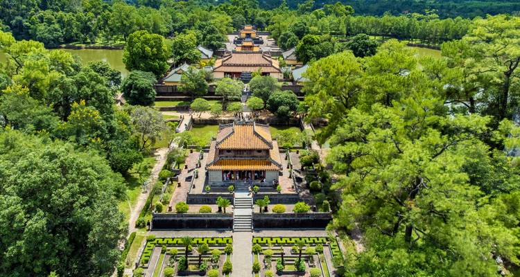 High-angle panorama of a royal Vietnamese citadel complex nestled in verdant forest
