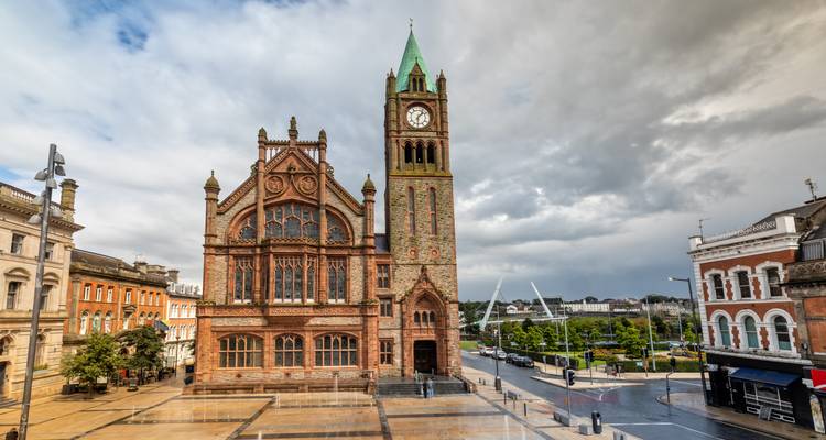 Beeindruckendes rotes Zunfthaus im gotischen Stil mit Glockenturm, das einen geräumigen Platz unter dramatischem Himmel in Londonderry dominiert.
