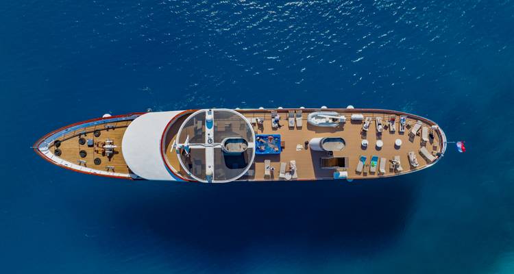 Vista aérea desde un dron del diseño de la cubierta de un yate de crucero flotando en el profundo mar Adriático azul.