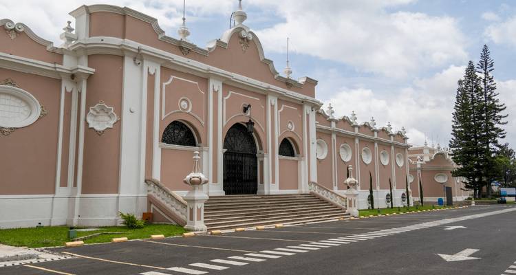 Neoclassical pink and white municipal building with grand stairway and decorative arches in Quetzaltenango