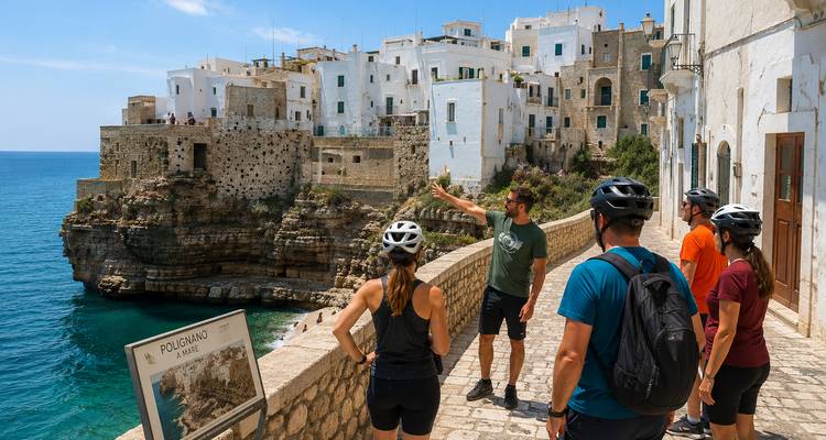 Le guide désigne la ville blanchie à la chaux perchée sur la falaise tandis que les cyclistes surplombent la mer Adriatique turquoise
