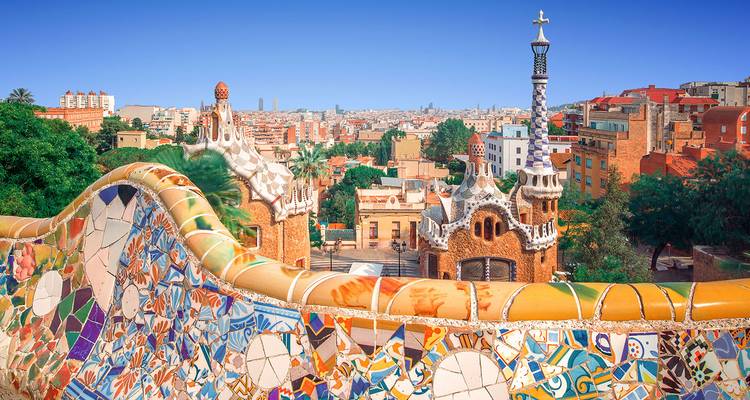 Terrasse en mosaïque colorée surplombant la skyline de Barcelone depuis le Parc Güell par une journée dégagée