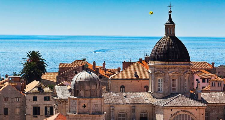 Las azoteas y cúpulas del casco antiguo de Dubrovnik frente al azul profundo del Mar Adriático bajo un cielo despejado.