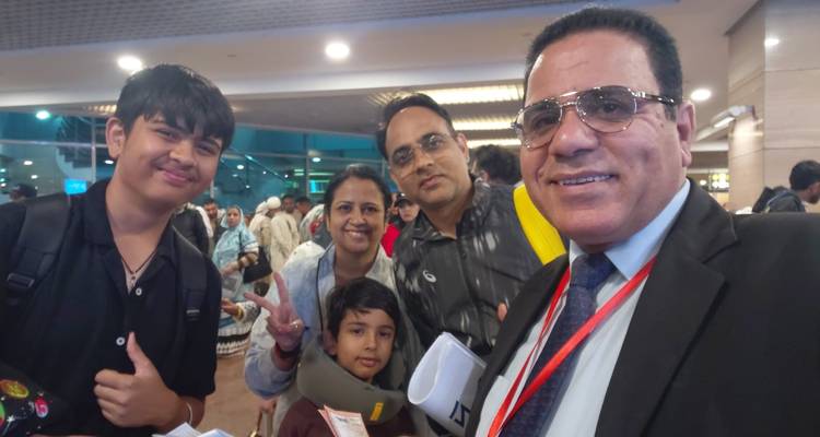 Selfie décontracté du guide avec sa famille dans la zone des arrivées d'un aéroport très fréquenté.