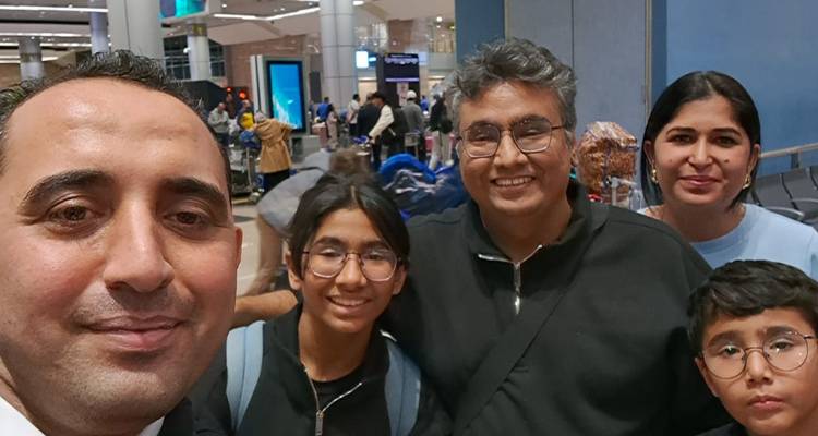 Selfie à l'aéroport avec le guide et la famille parmi les bagages et les voyageurs.