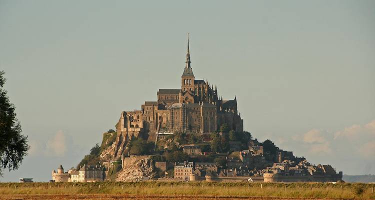 Mont-Saint-Michel abbey perches atop its tidal island rising dramatically from flat coastal plains.