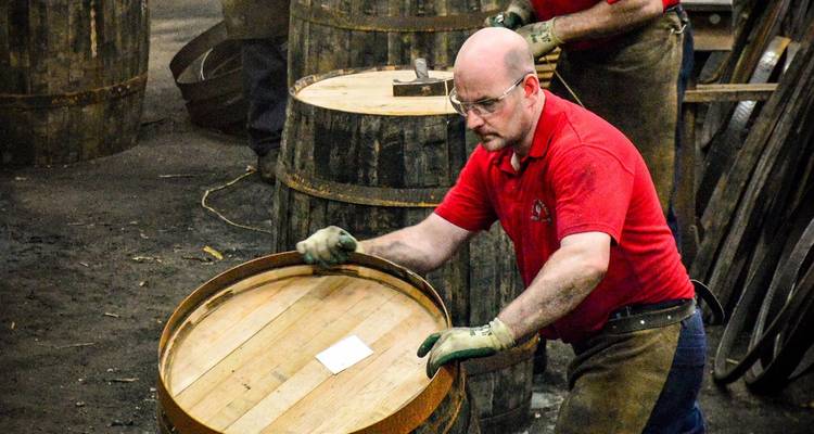 Tonneliers façonnant et roulant des fûts de whisky en chêne à l'intérieur d'un atelier