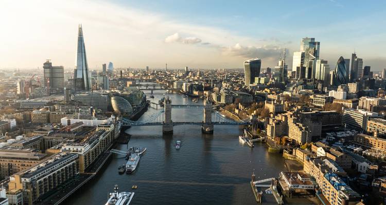 Dramatische Luftaufnahme der Themse in London mit der Tower Bridge, dem Shard und moderner Skyline bei Sonnenuntergang