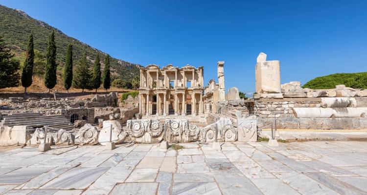 Symmetrische Marmorfassade der Celsus-Bibliothek von Ephesus gegen einen makellosen blauen Himmel.