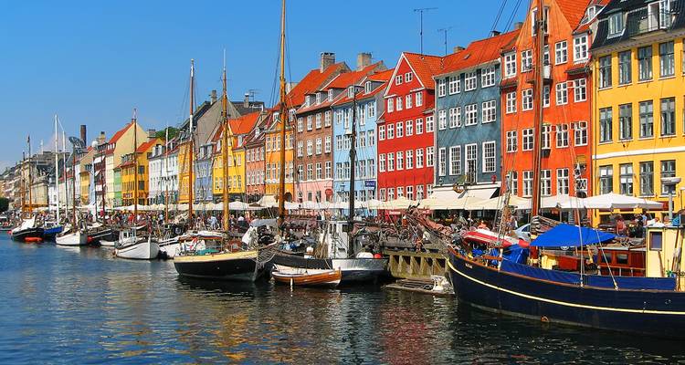Row of brightly painted 17th-century houses and moored boats along Copenhagen’s lively Nyhavn canal.