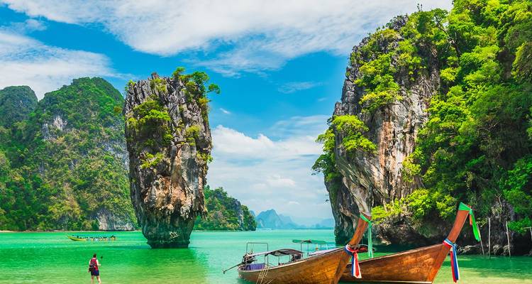 Iconisch James Bond Island, een kalkstenen karst die uit smaragdgroen water oprijst met longtailboten in de buurt.