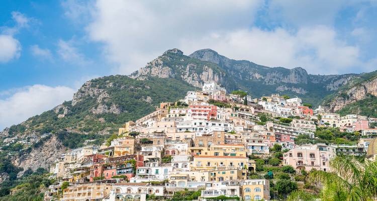 Las icónicas casas de colores pastel de Positano apiladas en un acantilado empinado bajo montañas escarpadas.