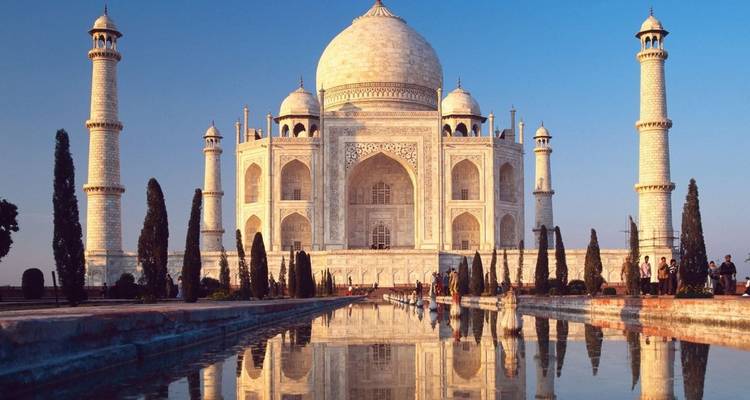 Das majestätische weiße Marmor-Taj Mahal spiegelt sich in seinem langen Becken im Licht der Morgenröte