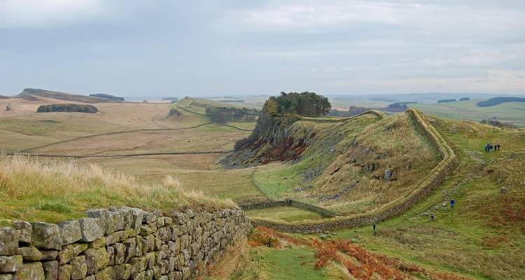 Vue panoramique de la Muraille d'Hadrien serpentant sur les landes ondulantes avec la maçonnerie au premier plan.