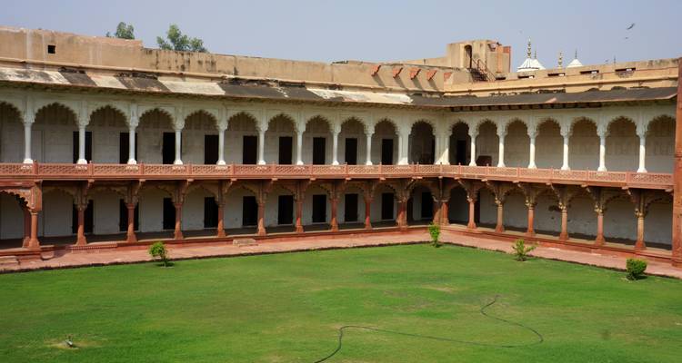 Patio grande rectangular del palacio de Fatehpur Sikri rodeado de columnatas de dos pisos.