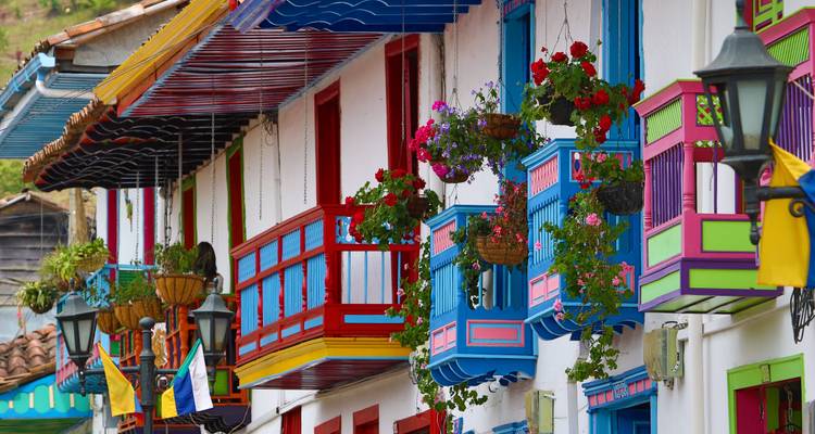 Close-up of brightly painted wooden balconies adorned with flowers in Salento