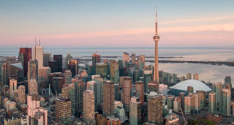 Skyline aérien de Toronto au lever du soleil avec la Tour CN s'élevant au-dessus des immeubles de grande hauteur et le lac Ontario.