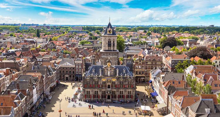 Panoramisch uitzicht vanaf het dak van het historische plein van Delft met het stadhuis en kerkentoren op een heldere dag.