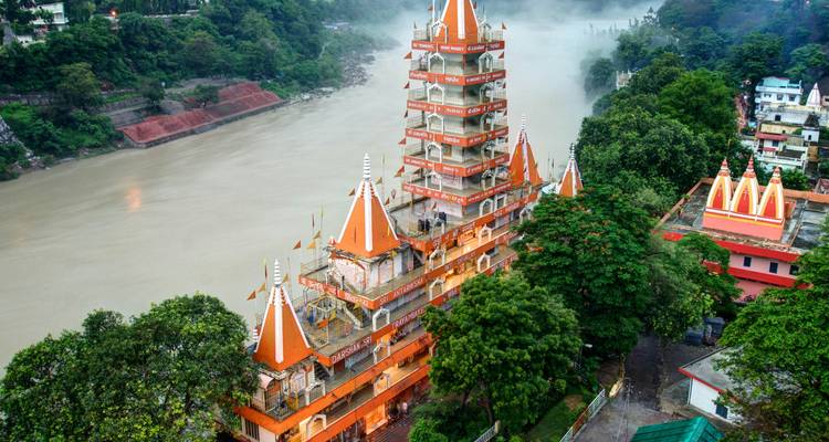 Le coloré temple de Trayambakeshwar s'élève au-dessus de la rivière Gange brumeux à Rishikesh.