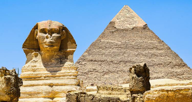 Iconic Sphinx gazes forward with the Pyramid of Khafre rising behind under a clear blue sky