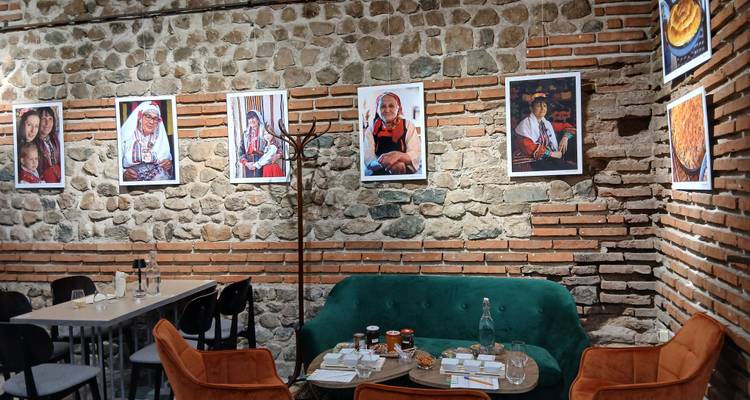 Intérieur chaleureux d'un café en pierre et brique avec des photographies de portraits culturels exposées