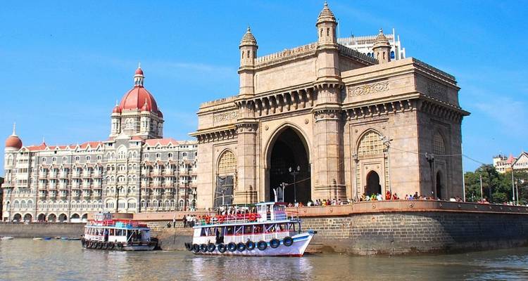 Gateway of India arch and Taj Mahal Palace hotel viewed from boats on Mumbai harbour