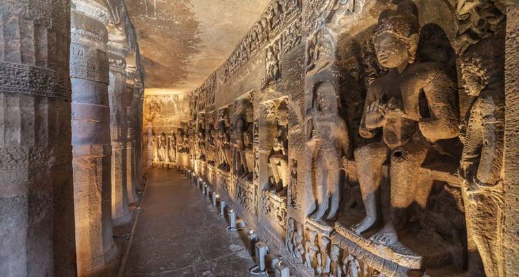 Interior corridor of Ajanta Caves adorned with intricate Buddhist rock carvings