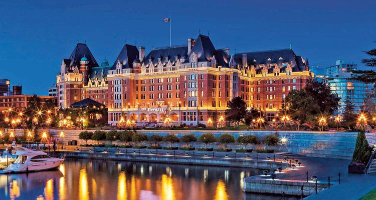 L'Hôtel Empress illuminé par des fées surplombe le port intérieur à l'heure bleue avec des reflets dans l'eau
