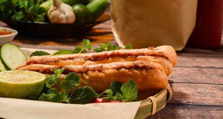 Close-up of Vietnamese banh mi sandwich garnished with herbs and lime