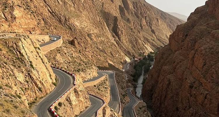 Slingerende kronkelende bergweg uitgehakt in rode rotsen van Todra Gorge