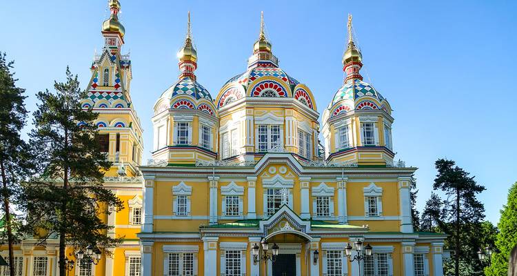 Farbenfrohe russisch-orthodoxe Zenkov-Kathedrale mit leuchtend gelben Wänden und kunstvollen Kuppeln in einem Park