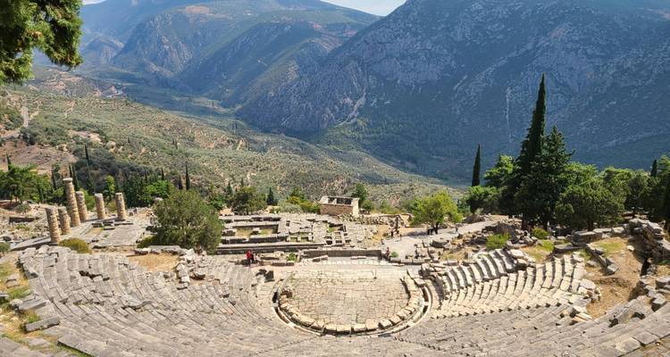 Vue panoramique d'un ancien amphithéâtre en pierre dominant une vallée verdoyante luxuriante et des montagnes lointaines