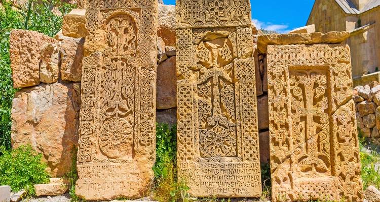 Vue rapprochée des sculptures de khachkars arméniens colorés avec des motifs complexes.