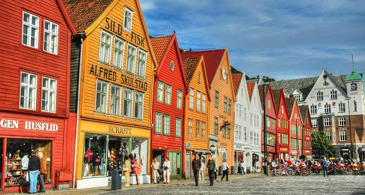 Rangée d'entrepôts colorés en bois de Bryggen avec une place animée en façade