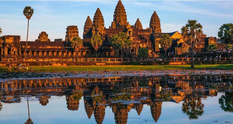 Les tours emblématiques d'Angkor Wat se reflétant dans un étang calme sous la lumière chaude du matin.