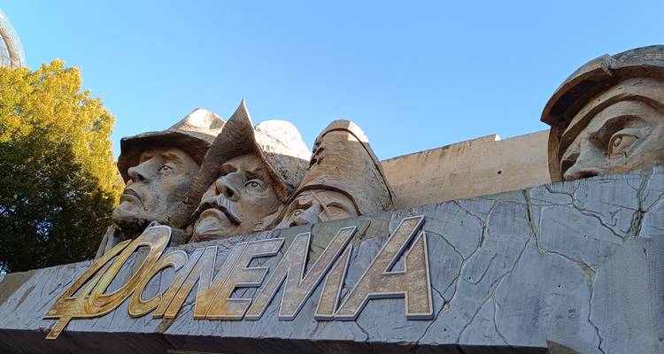 Toma de ángulo bajo de la entrada de un cine 4D decorada con grandes cabezas de vaquero esculpidas y señalización
