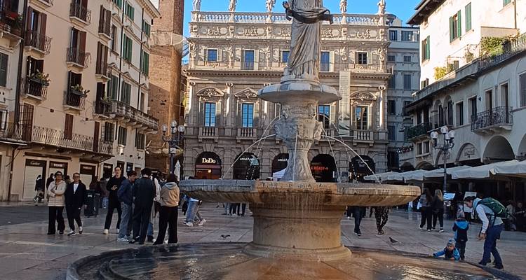 Plaza de las Hierbas abarrotada en Verona con la Fuente de la Madona Verona frente a las fachadas renacentistas