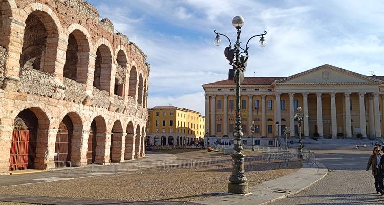 Vista amplia de la plaza con la Arena de Verona junto al Palazzo Barbieri neoclásico bajo un cielo despejado