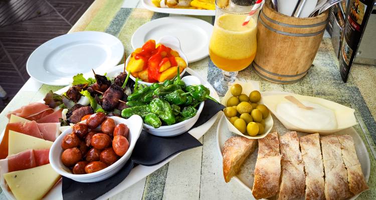 Assortiment coloré de tapas espagnoles avec du pain, des olives et du jus frais