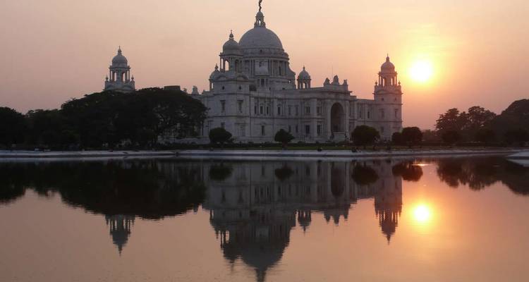 Le lever du soleil au-dessus du Victoria Memorial se reflétant dans les eaux tranquilles de Calcutta, en Inde.
